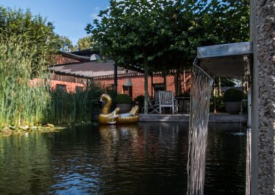 Ein Wasserfall, der in einen Teich fließt, mit einem goldenen Schwimmreifen im Hintergrund.