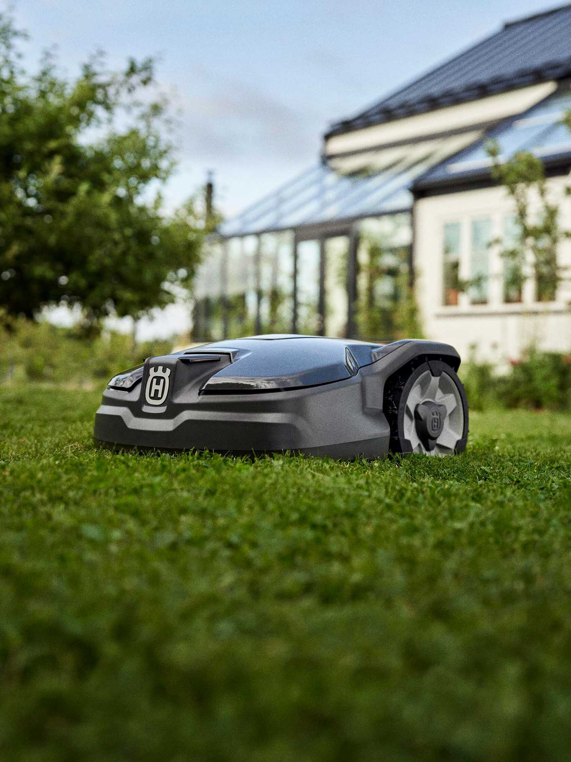 Automatischer Rasenmäher Automatischer Rasenmäher von Husqvarna auf einer grünen Rasenfläche im Garten.