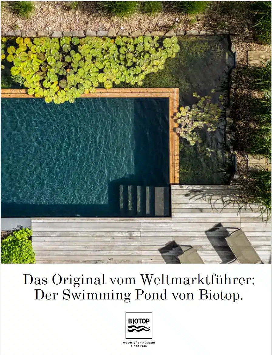 Biotop Swimming Pond, Gartenpool mit Holzdeck und Naturufer Luftaufnahme eines Swimming Ponds mit Holzterrasse und Natursteinmauer; „Der Swimming Pond von Biotop“.